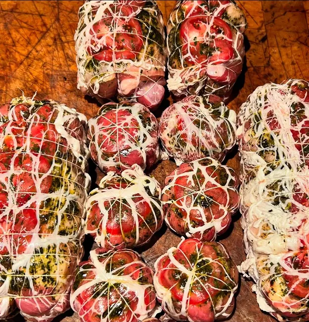 Rôtis de viande farcis et ficelés avec des herbes sur une planche en bois à Palaiseau en Essonne 91