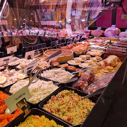Large étalage de charcuterie et de salades traiteur variées dans un magasin à Palaiseau en Essonne 91